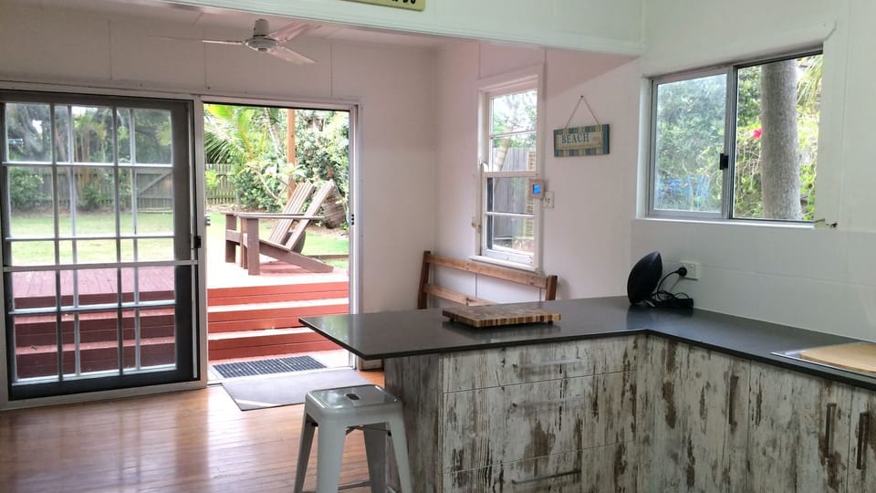 Kitchen leads out to large fenced backyard.