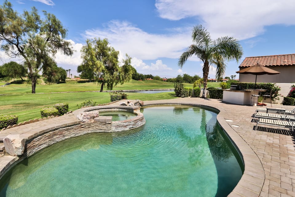 The pool features a jacuzzi and baja ledge with optional umbrella