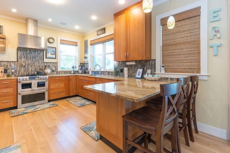 View of the kitchen with counter bar seats for visiting, very open and spacious, comes complete with cook ware and dishes, dish soap and paper towels for your arrival.