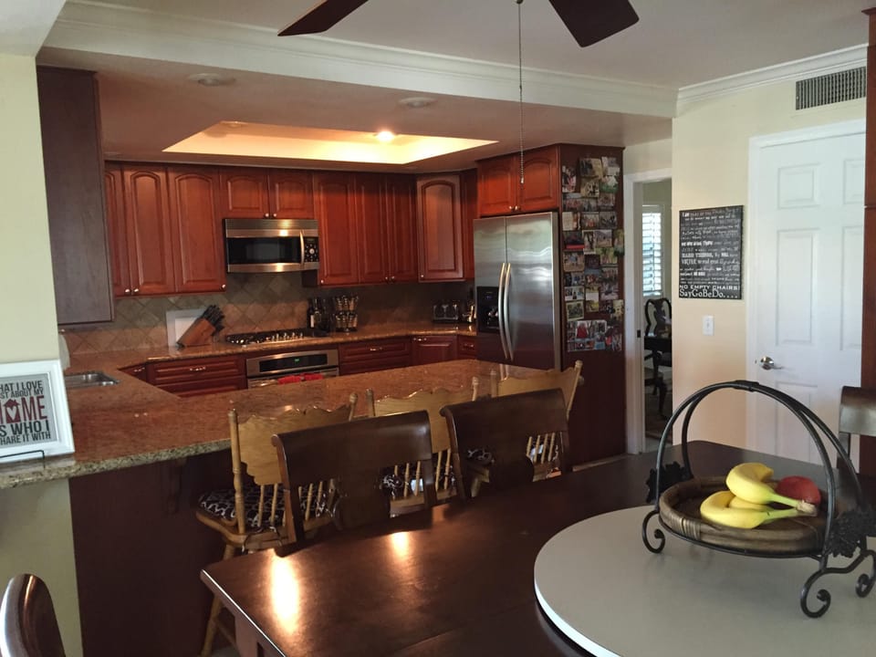 Kitchen with oven, microwave, trash compactor. Seating for 8 at table.