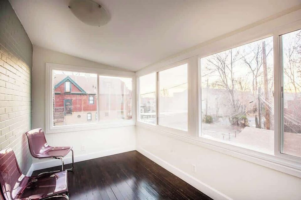 Cozy sun-filled room with wide windows and peaceful views, creating a perfect spot to unwind.