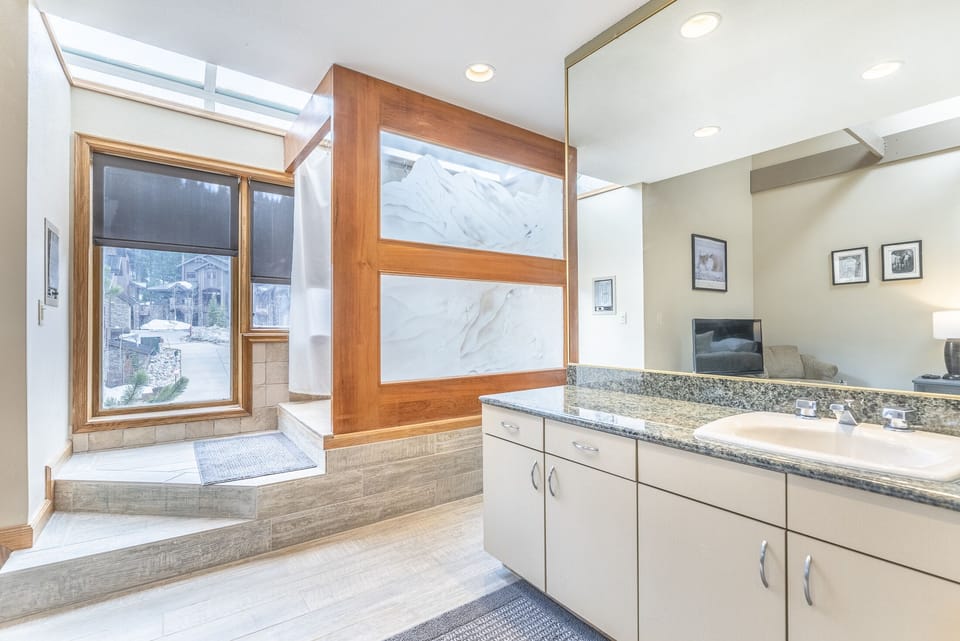 En-Suite Bathroom - Large soaking tub with shower, separate vanity area, and a water closet around the other side.
