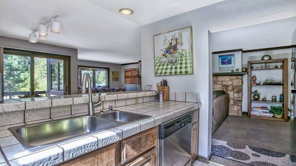 Functional kitchen with a large sink, plenty of prep space, and easy access to the living room.