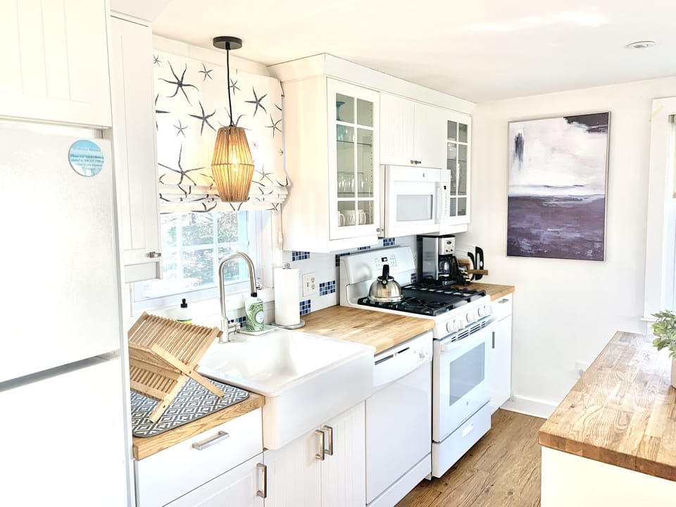 Light and bright kitchen with butcher block top island. 