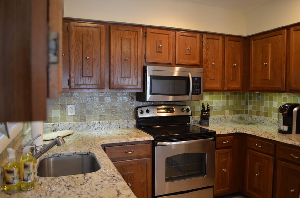 Full kitchen with Keurig machine, microwave, and stove/oven.