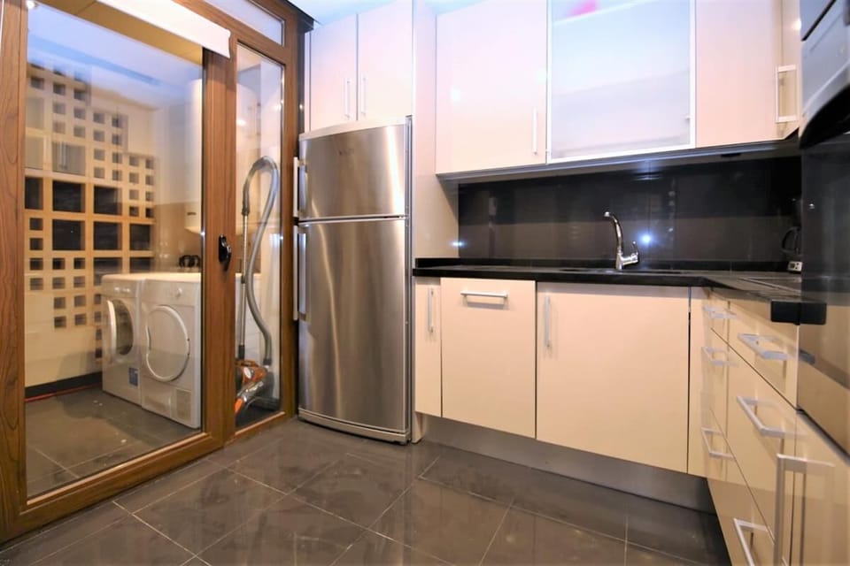 Modern kitchen is fully fitted with quality appliances and has a laundry room