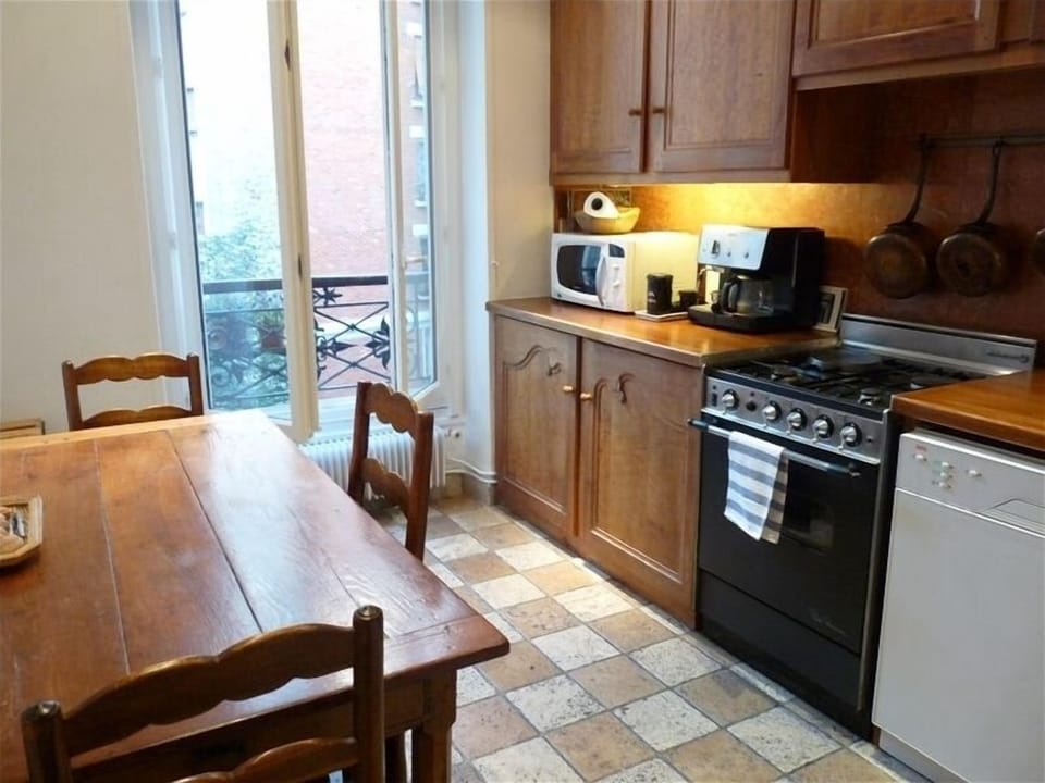 Spacious kitchen with view of courtyard, Italian tiles & antique table