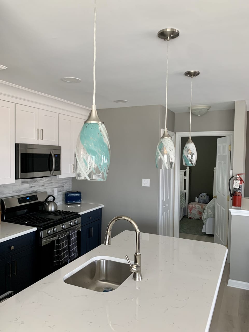 Brand new kitchen with quartz countertops and new lighting.