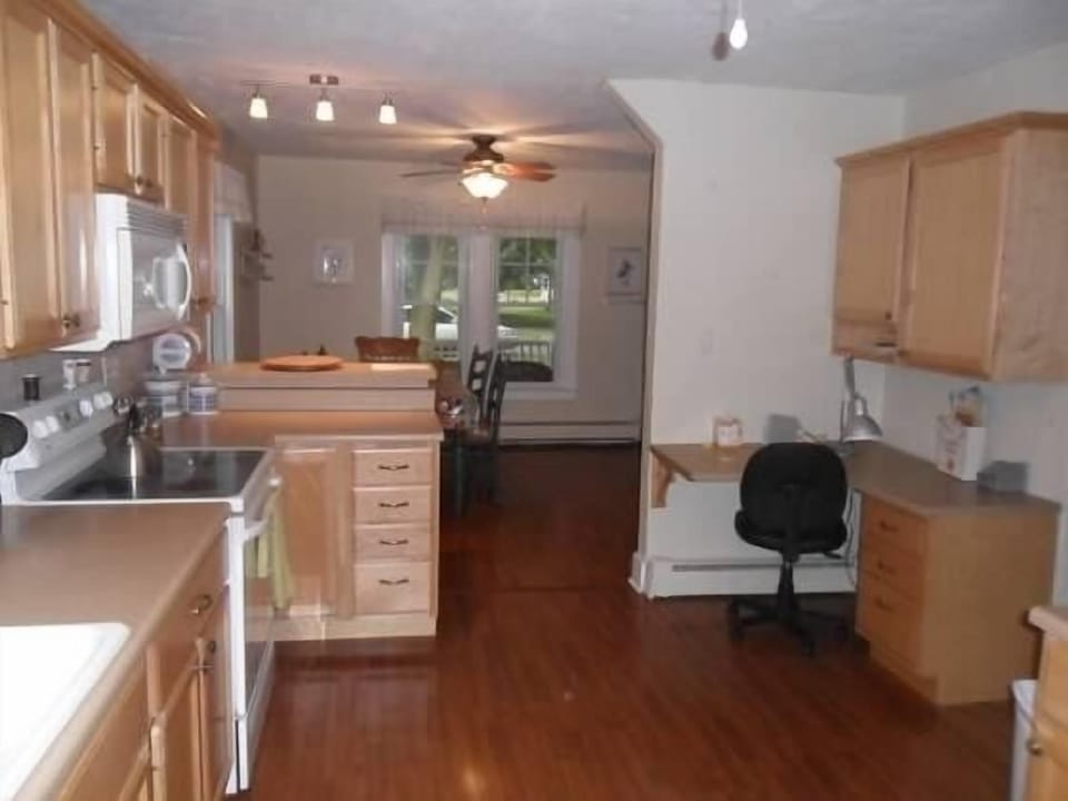 Kitchen with small office area looking into dining area with large windows