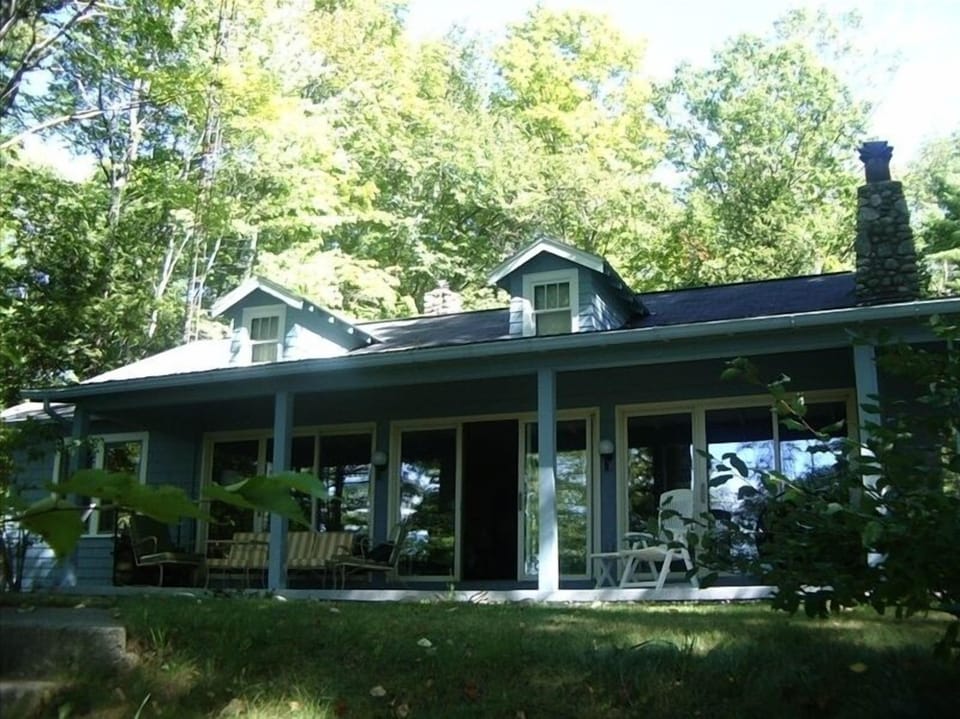 View of cottage from the lake side of property.  Covered porch.