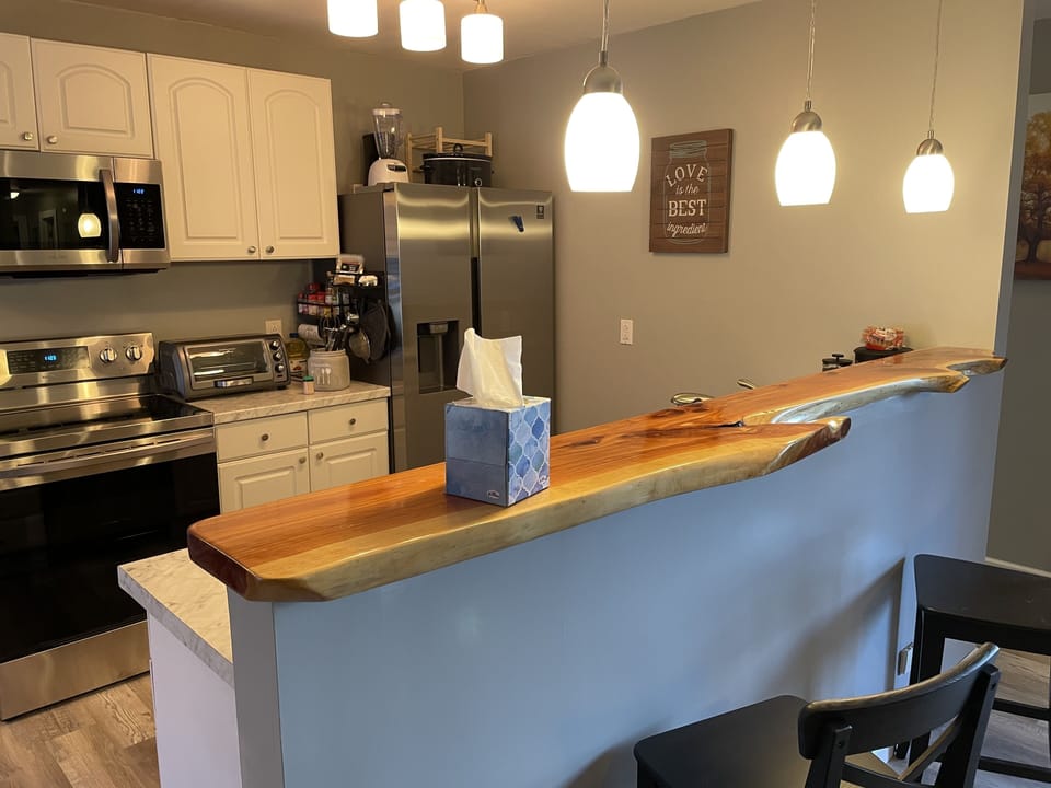Our beautiful kitchen with live edge cedar bar top and brand new appliances