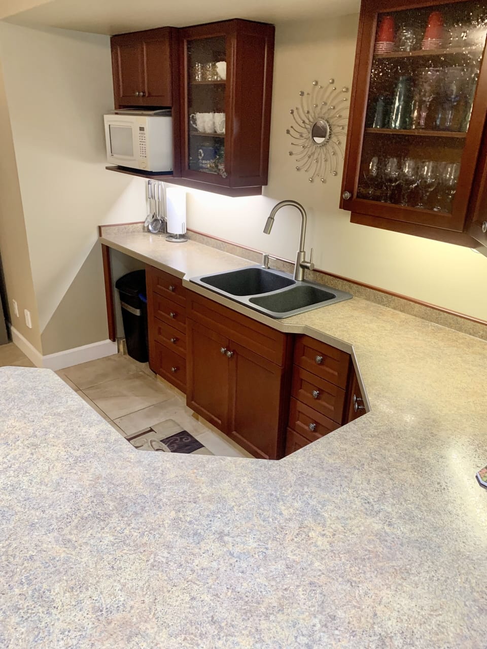Kitchen with hot plates toaster, coffee maker, microwave, dishes and pots, pans