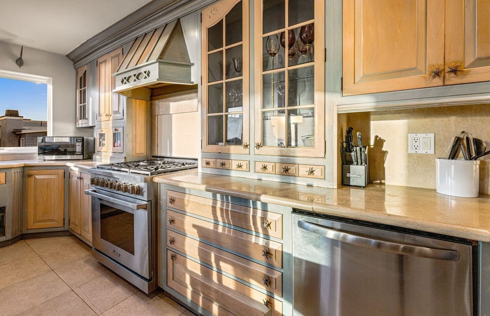 The gourmet kitchen is thoughtfully appointed with stainless steel appliances, custom cabinetry, and generous counter space
                