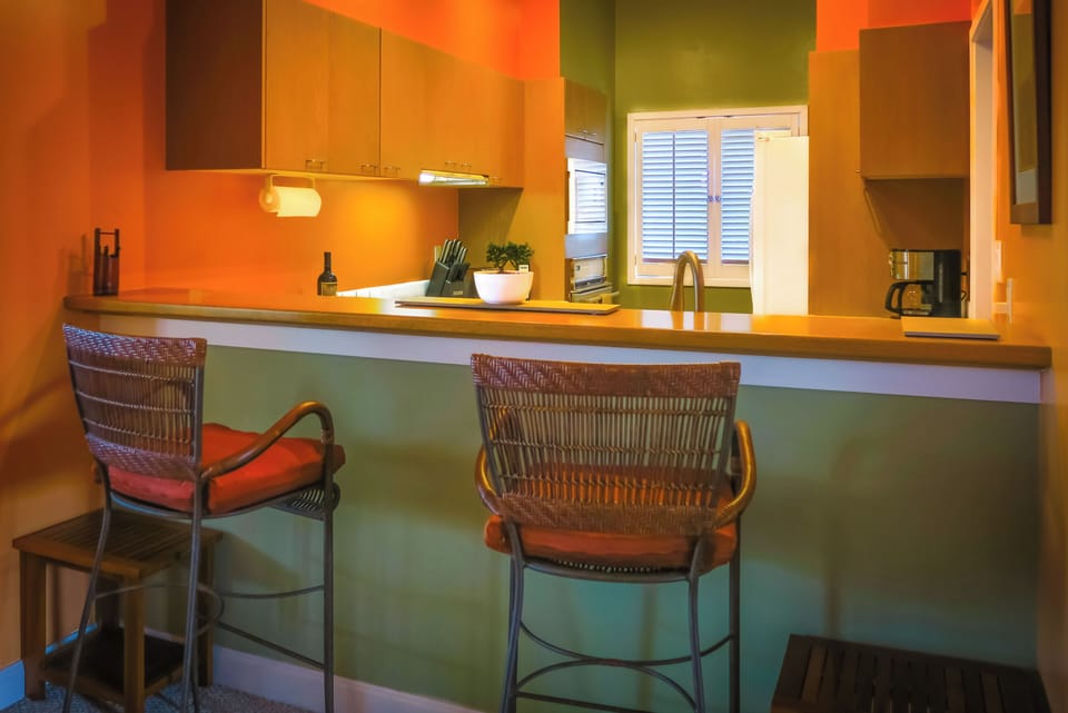 Breakfast bar opens into fully supplied kitchen.
