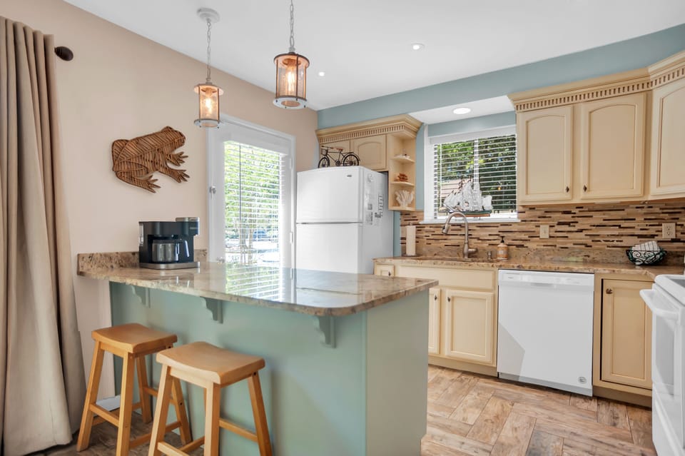 Kitchen has high-end granite countertops and glass mosaic tile backsplash