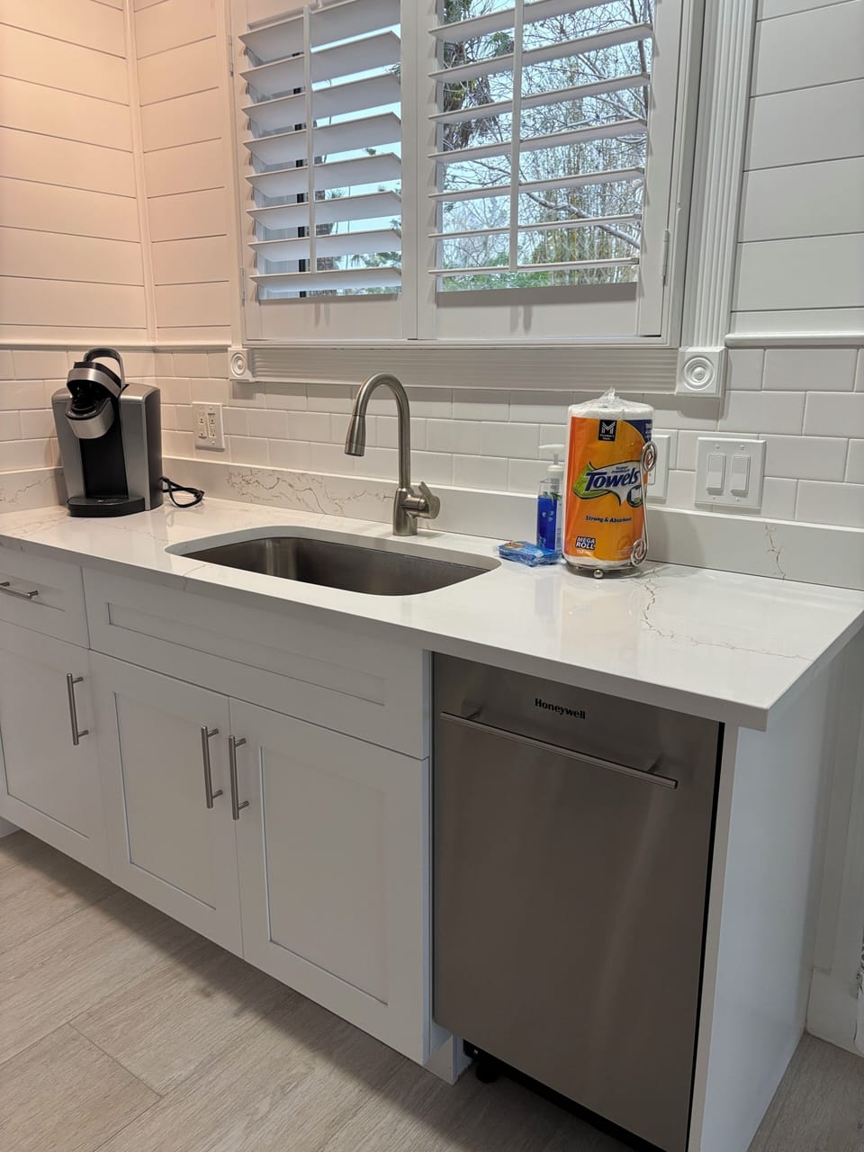 Kitchen with Keurig coffee machine, dish washer, fridge and freezer.
