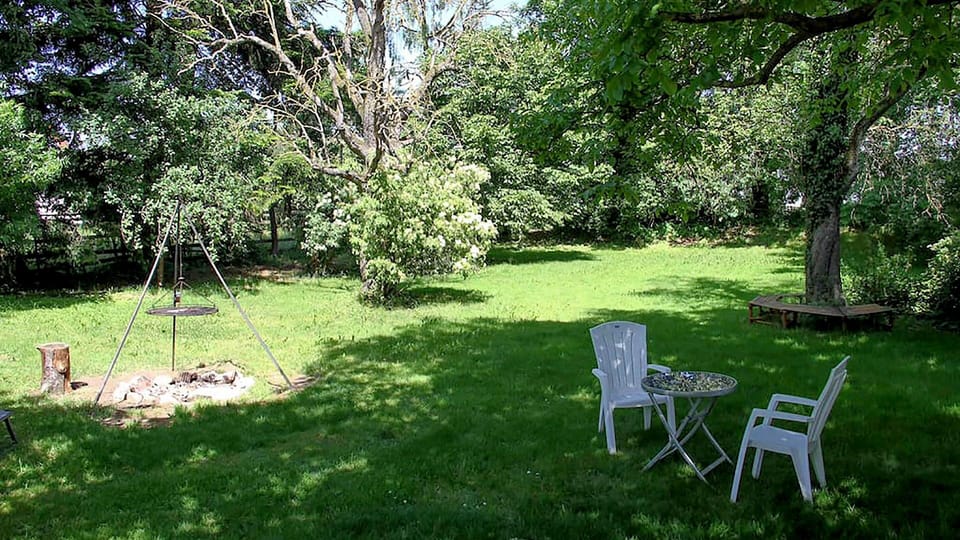 Garden with outdoor and kettle grill with many tables and chairs/benches