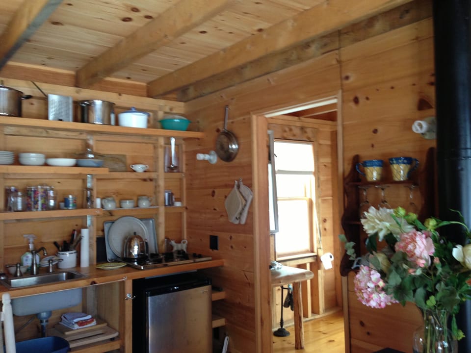 Kitchen in Bunk House Cabin view into large bathroom and gas fireplace on right