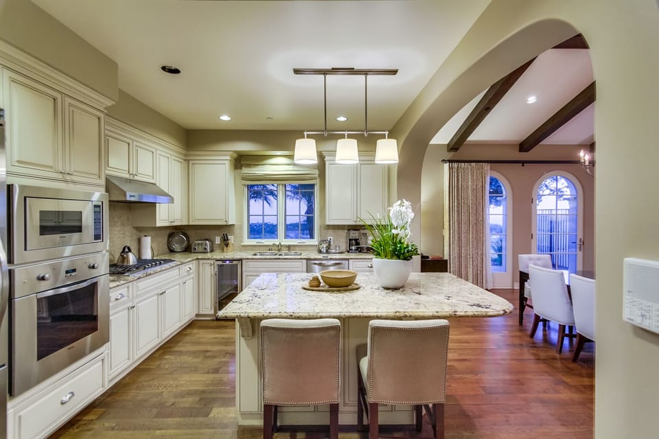 Gourmet kitchen with granite counters, Viking stove, oven, and refrigerator
