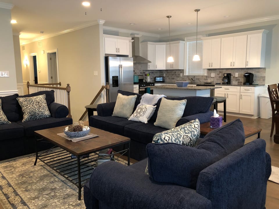Living Area open to Kitchen and Dining Area with flat screen tv and ceiling fan