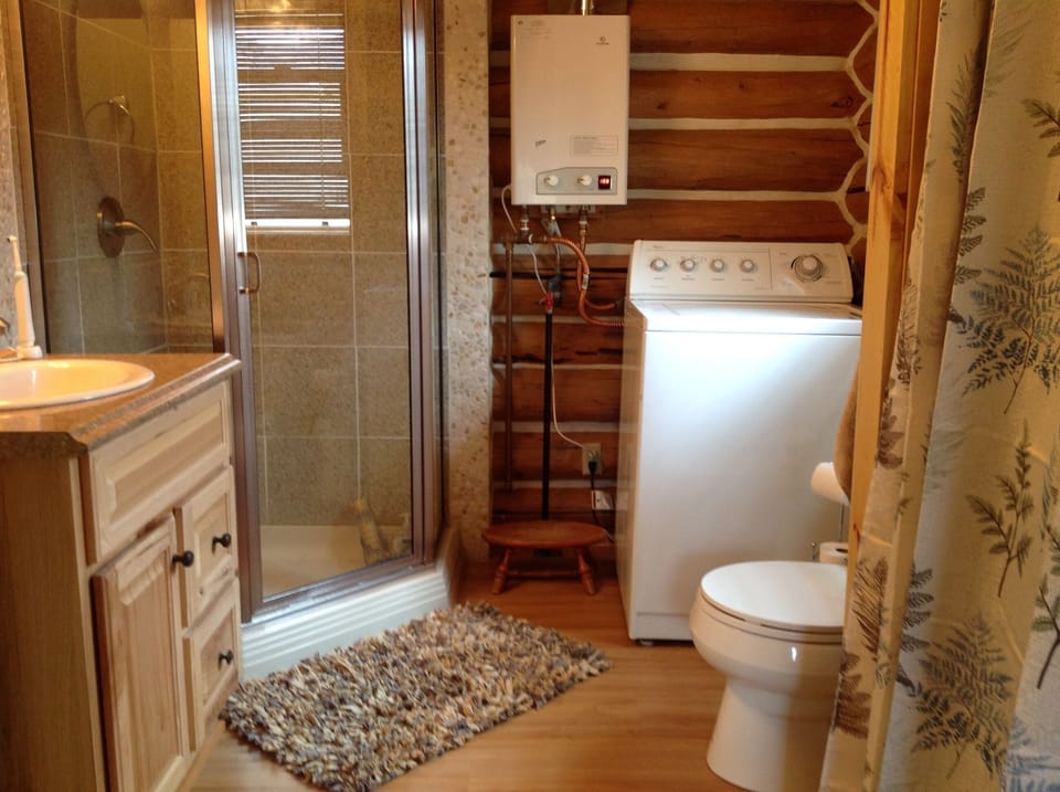 Bathroom that includes washing machine and clothes closet  