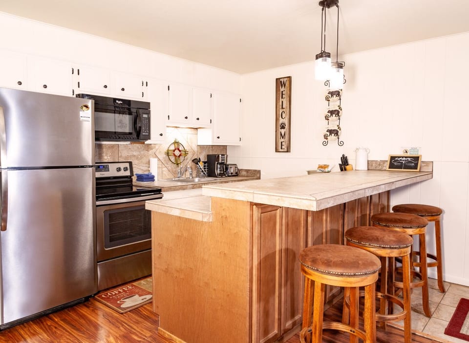 Your well-appointed kitchen invites morning coffee and easy meal prep with modern appliances, ample counter space, and a cozy breakfast bar perfect for casual dining or conversation.