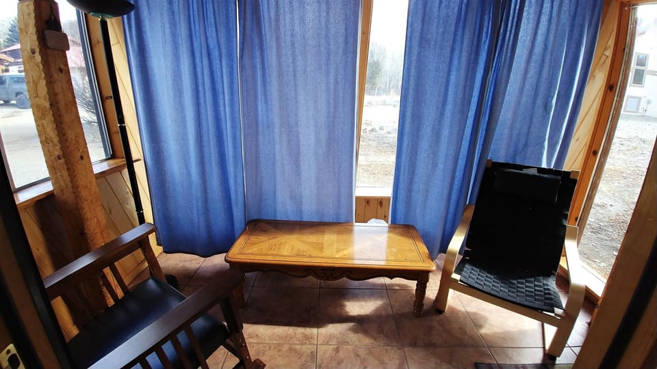 Unwind in your private seating nook, where soft blue curtains frame natural light and peaceful views. Your quiet retreat for morning coffee or evening reflection awaits.