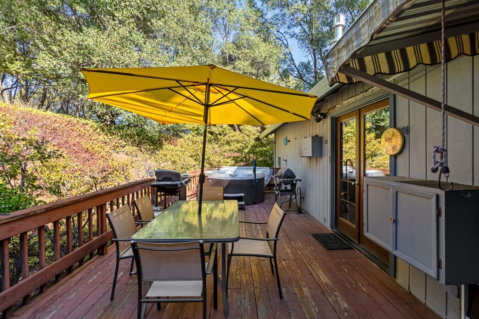 Back deck with table, chairs, umbrella, grill and hot tub