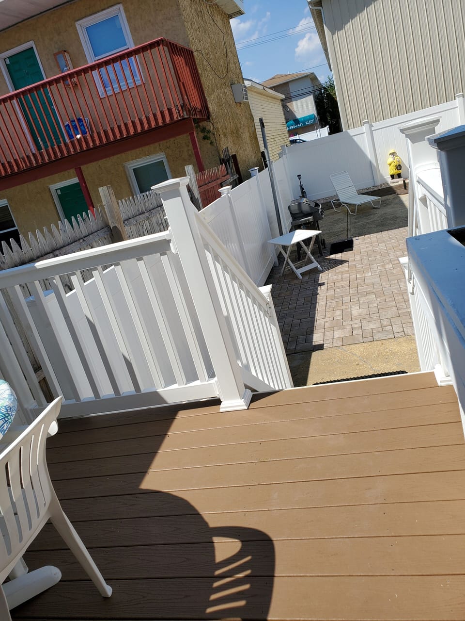 Deck leading to large yard with grill.. 