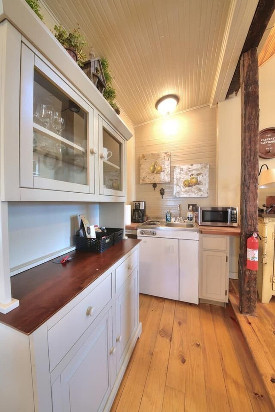 Kitchen with mini refrigerator, two-burner stove top, microwave, & coffee maker.