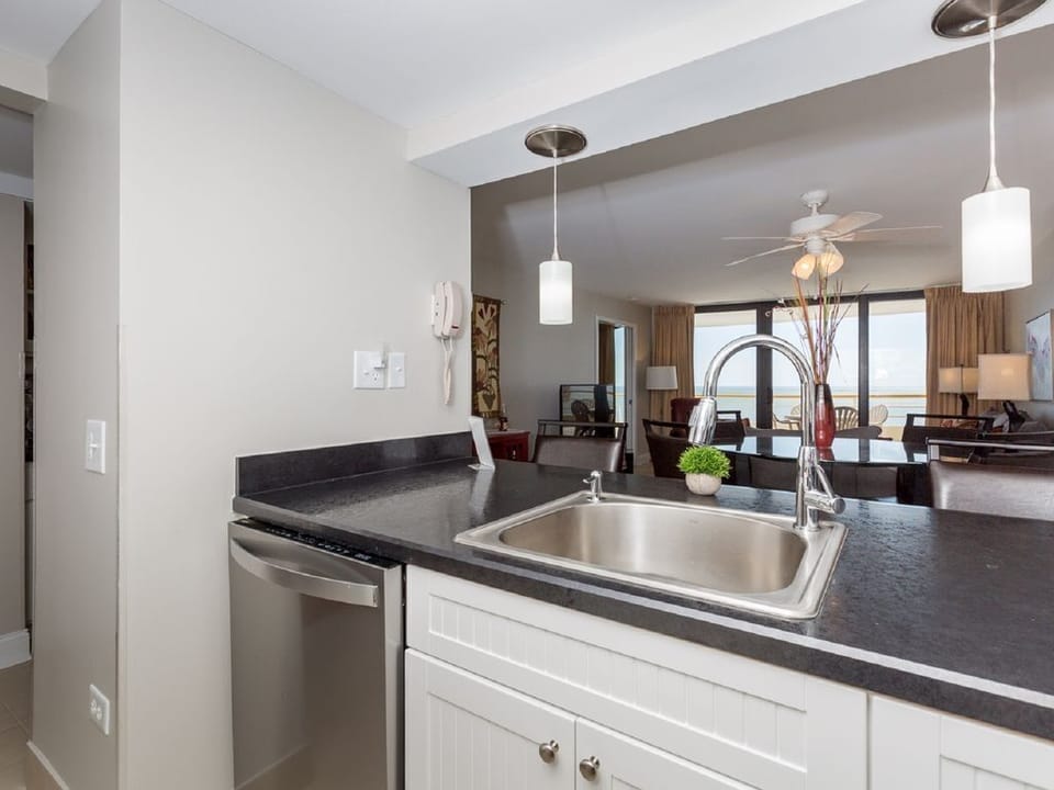 Newly remodeled kitchen looking across bar through dining area to living area