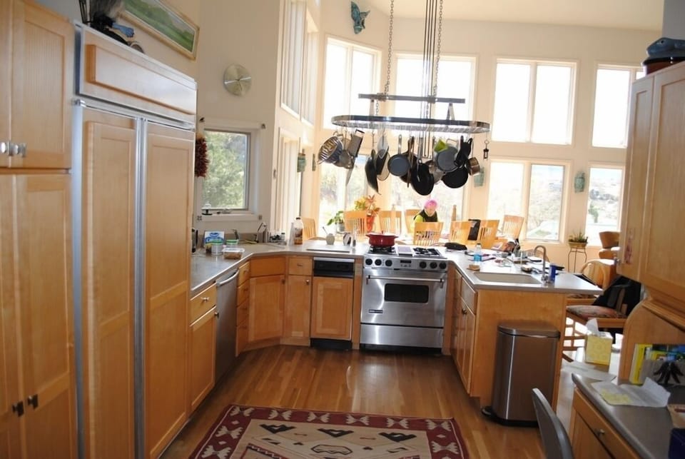 A chef's kitchen with built in refrigerator and two ovens