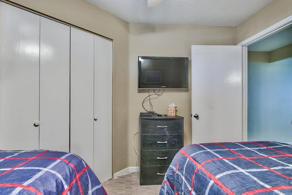 Guest bedroom has TV and DVD player and large closet for storage.