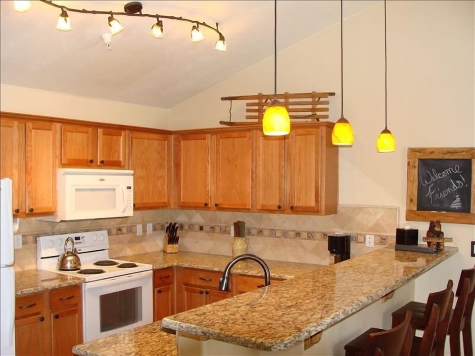 Large updated kitchen with new slab granite counters and travertine backsplash.