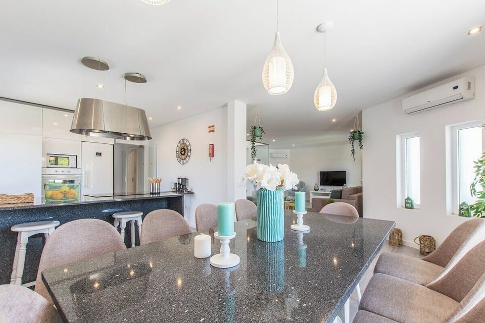 Open-plan kitchen and dining area with grey stone countertops — Villa Juliana, holiday villa in Loulé
