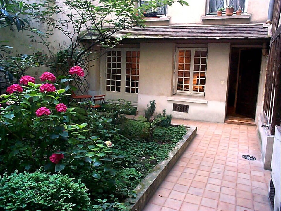 View from courtyard toward apartment door (open) and windows.