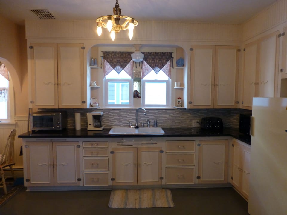 Deep double sink, toaster oven, coffee pot, microwave and toaster .