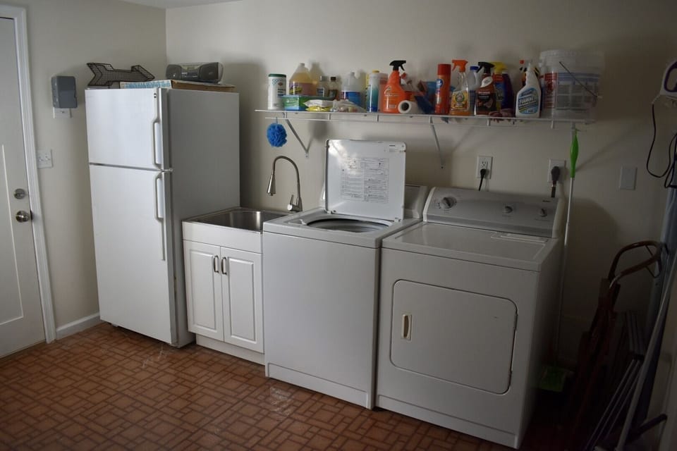 Off the kitchen is a half bath and laundry area with additional fridge