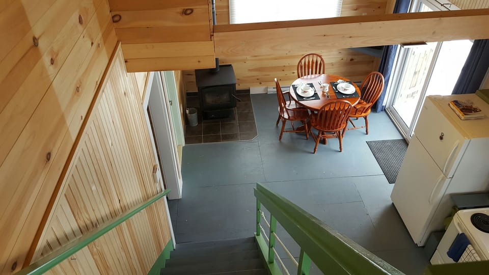dining area and wood stove looking from stairway to 2nd floor