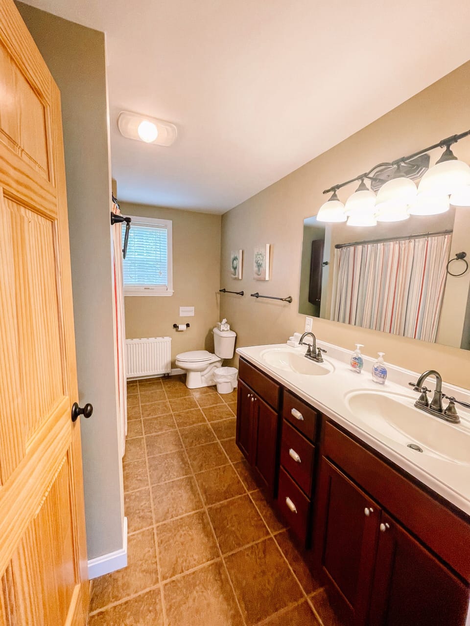 Downstairs full bathroom with dual sinks, walk in shower with seat and grab bar