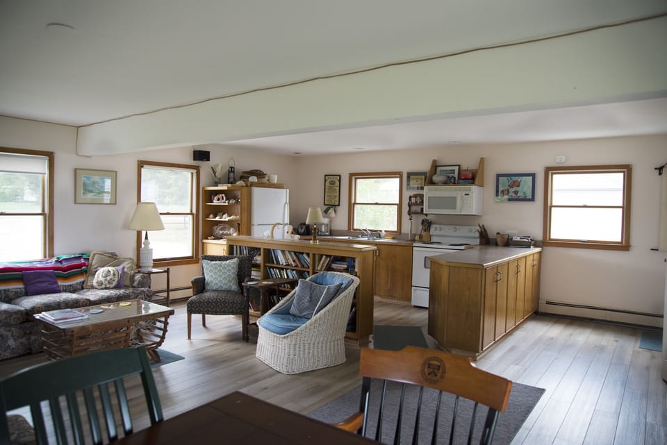 First floor living room, dining area, open kitchen. Porch access and ocean view