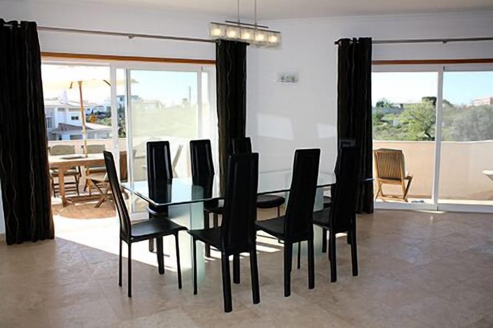 The dining area opens onto a wraparound balcony with country and sea views