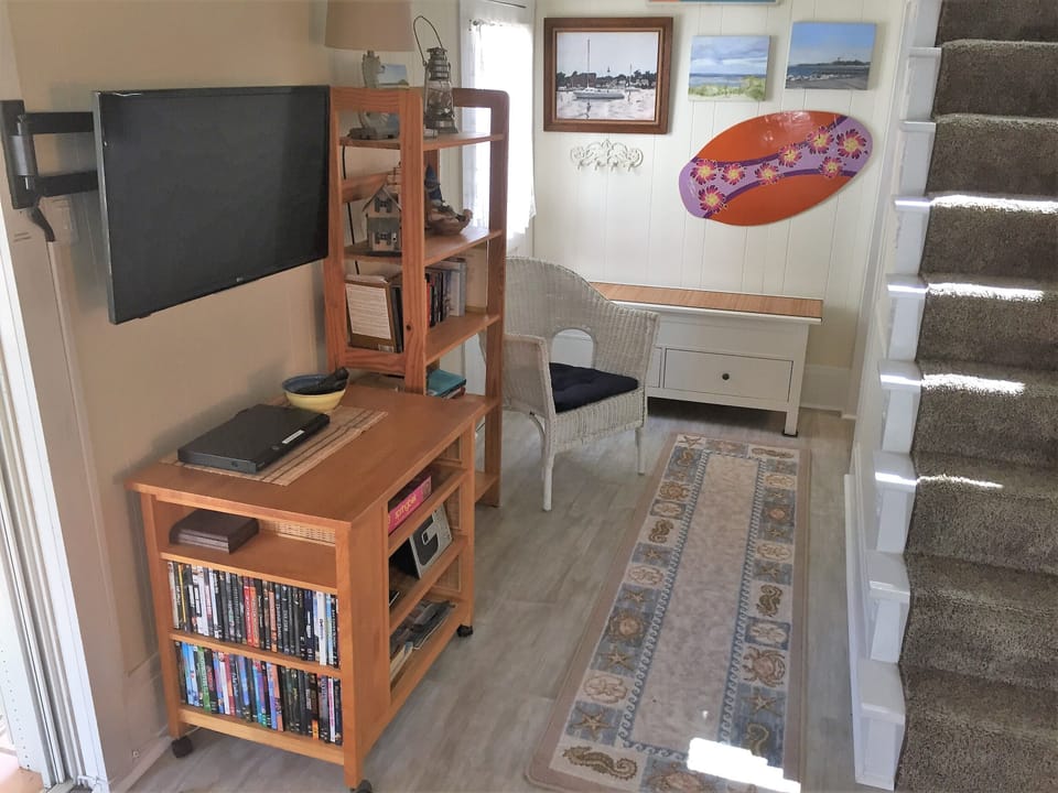 Entertainment center with DVD player and movies.
Bathroom behind the stairs