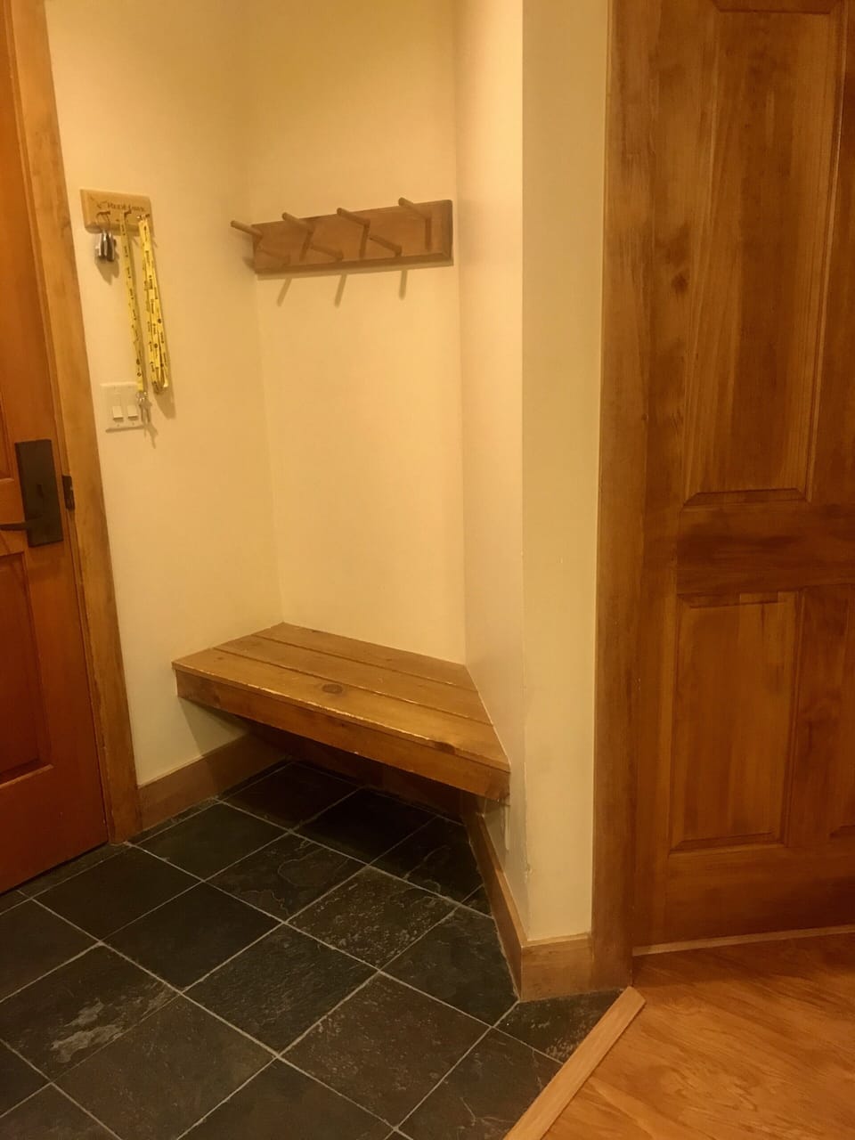 Sitting area to remove boots with storage hooks above.