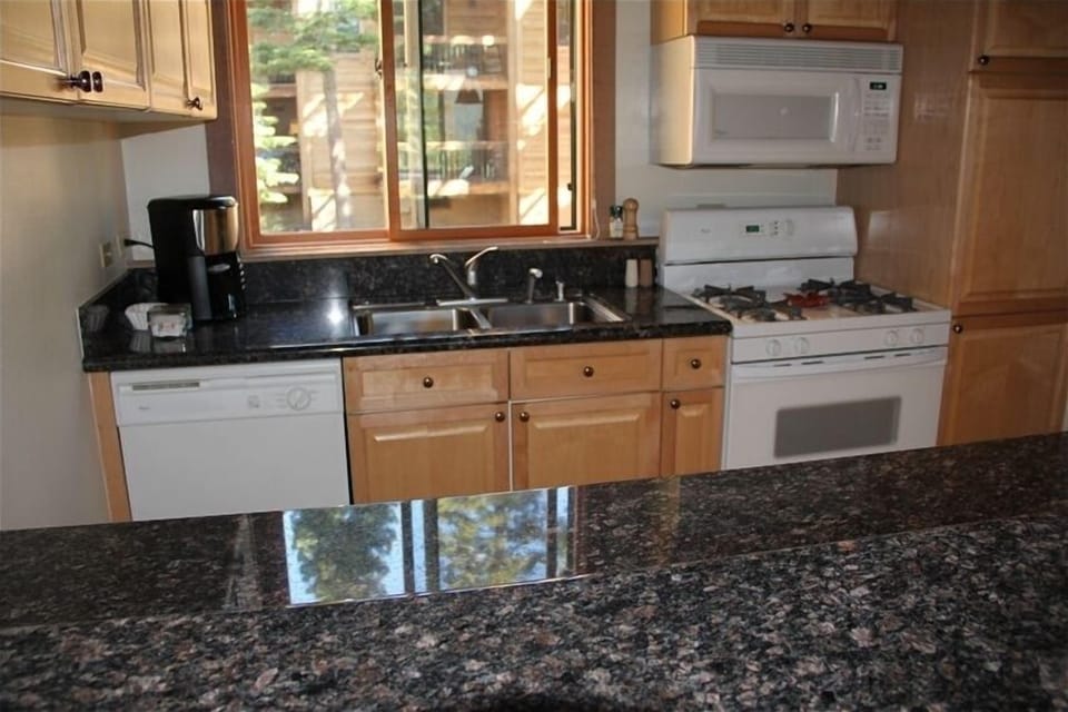 Updated kitchen has granite counters and gourmet cooking supplies.