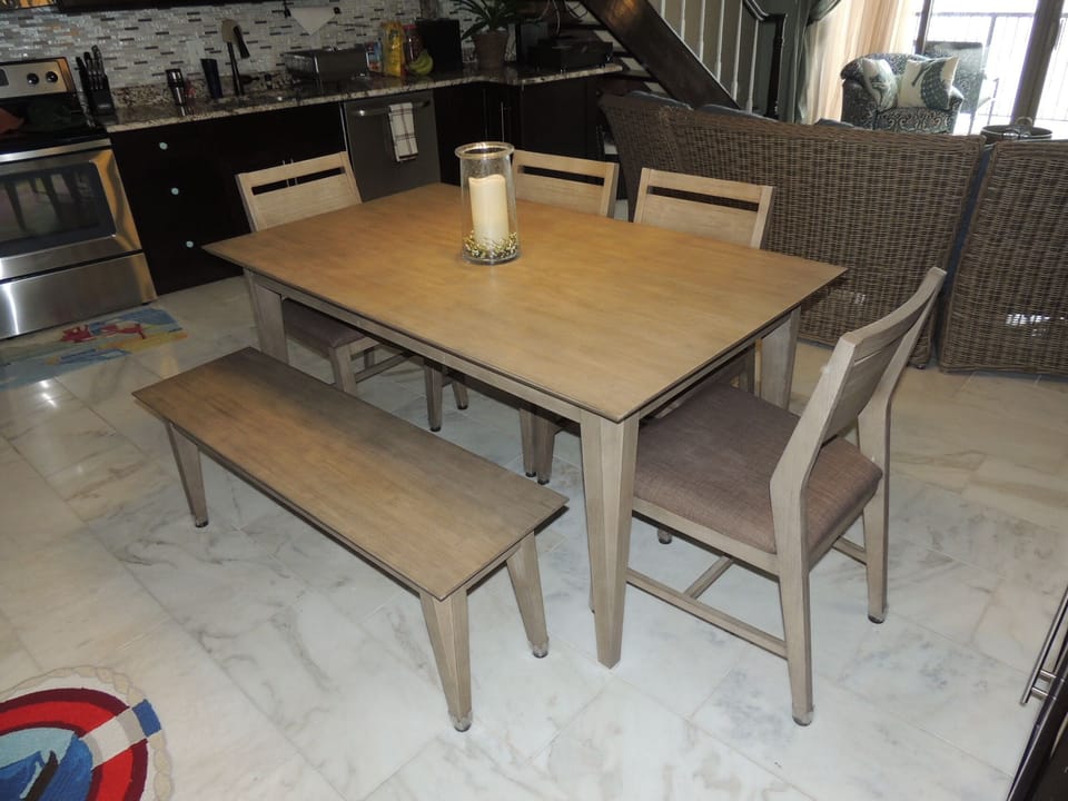 Dining set.  Seats 6-7.  White marble floors.  Near bar/game/DVD cabinet.