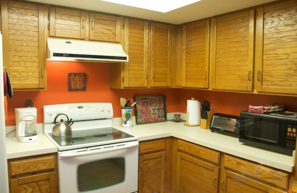 The kitchen features an electric range, fridge, DW, microwave and toaster oven. 