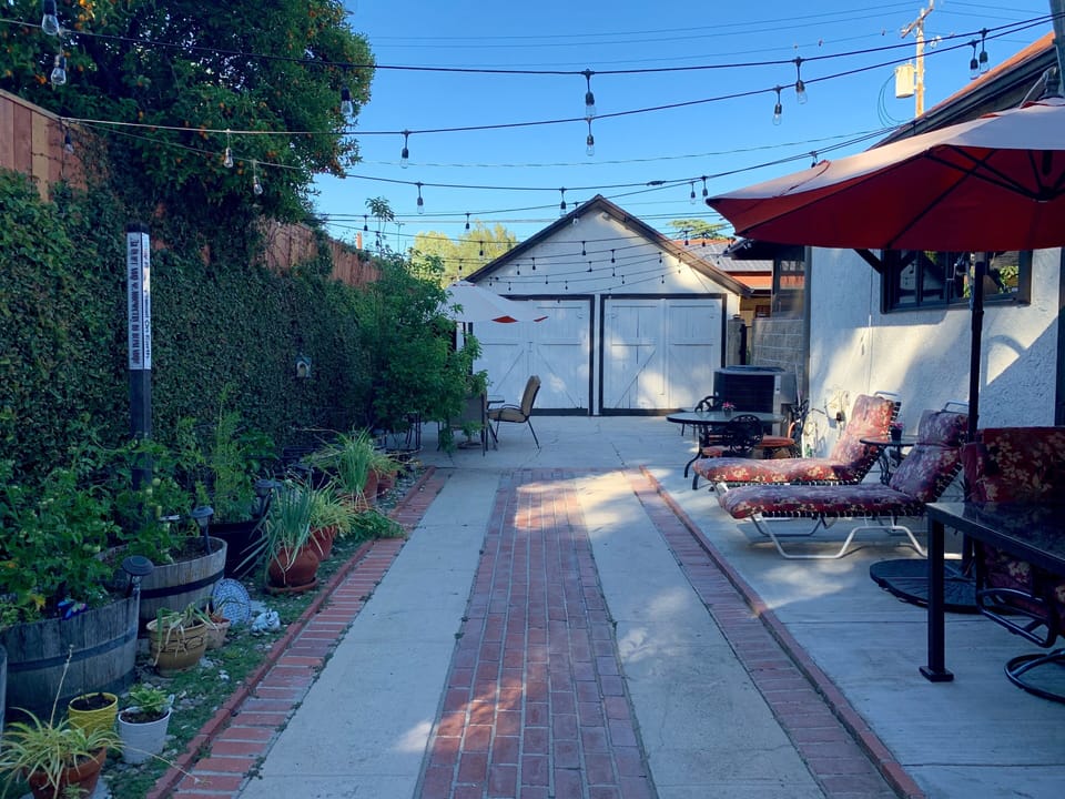 Large, safe, and secure private yard with Bistro lights and lounge/dining areas.