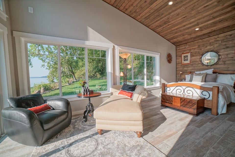Boathouse wing Bedroom with views of lawn and water