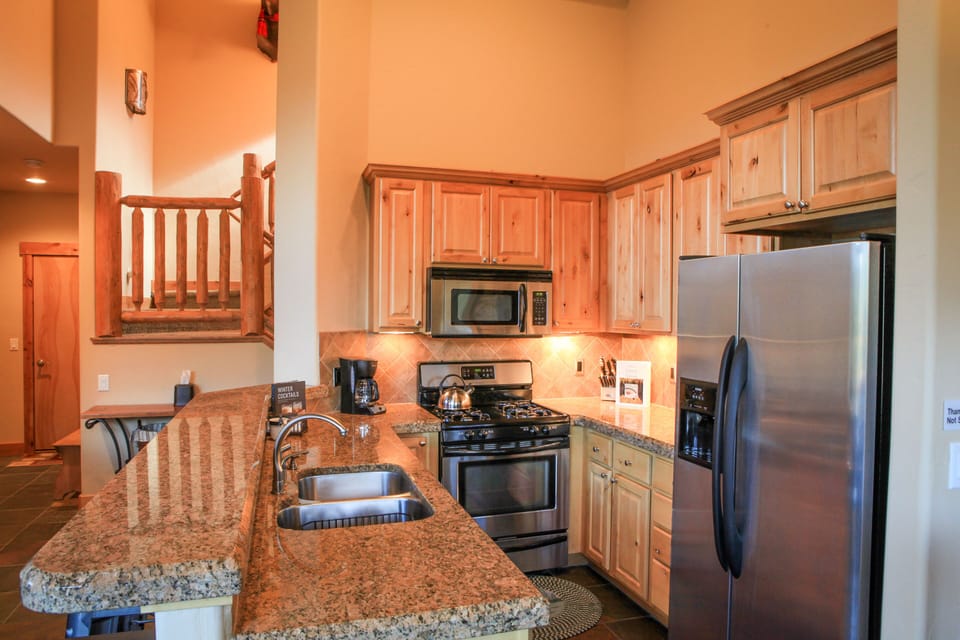 Kitchen with solid granite counters and stainless appliances.
